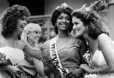 A fair queen is congratulated by fellow contestants.