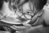 A youngster partakes in a watermelon contest.