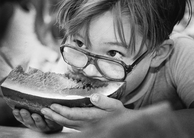 A youngster partakes in a watermelon contest.